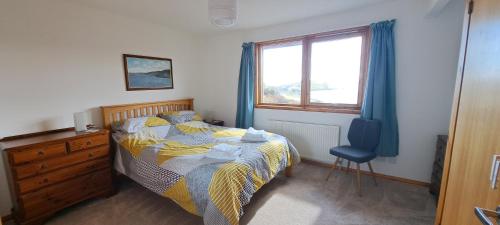 a bedroom with a bed and a dresser and a window at Solheim Self Catering in Whiteness