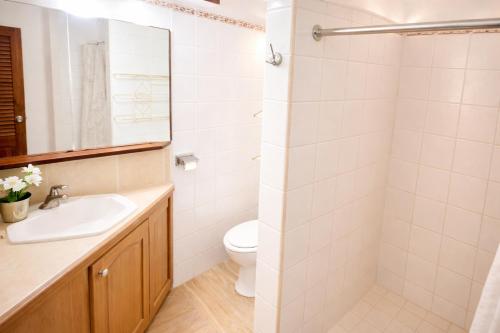 a bathroom with a sink and a toilet and a mirror at H Boutique Blessed in Tela