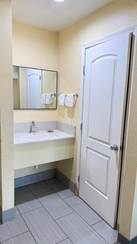 a bathroom with a sink and a mirror at Citrus Inn & Suites in Porterville