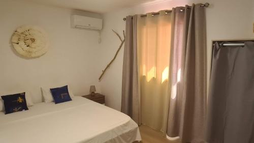 a bedroom with a bed and a curtain at Paradies Caraibes IV in Les Abymes
