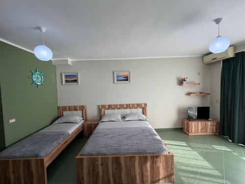 a room with two beds and a tv in it at Eri Apartments 4 in Shëngjin