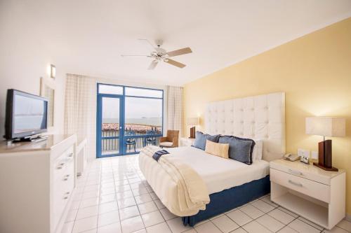ein Schlafzimmer mit einem großen Bett und einem TV in der Unterkunft El Cid Marina Beach Hotel in Mazatlán