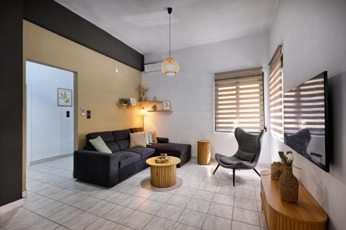 a living room with a couch and a table at El Dorado Corner with Hot Tub in Chania