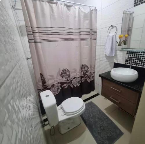 a bathroom with a toilet and a shower curtain at Refúgio Aconchego in Sorocaba