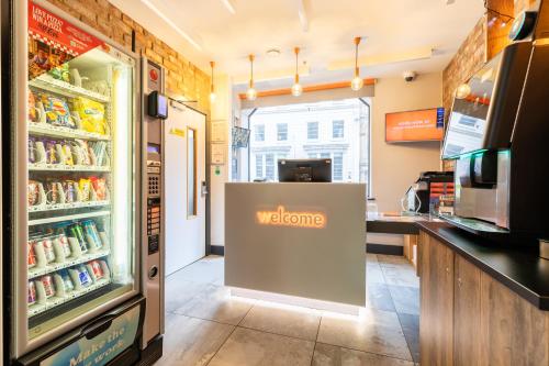 a store with a welcome sign in front of a refrigerator at easyHotel Liverpool in Liverpool