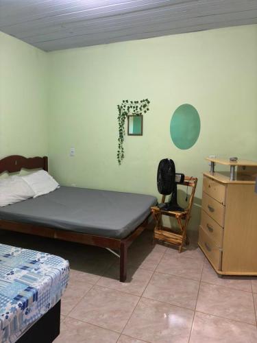 a bedroom with a bed and a desk and a chair at casa em Vila Verde Búzios in Búzios