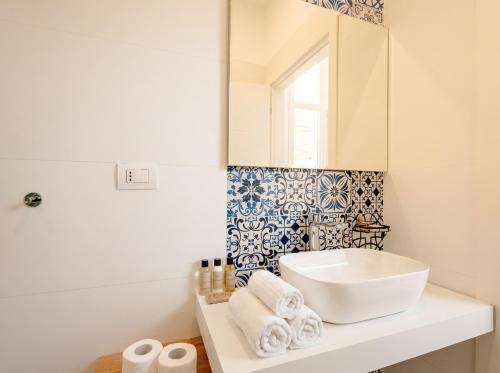 a white bathroom with a sink and a mirror at SPA & RELAX Aesthetic Apartment 50m dal mare in Monopoli