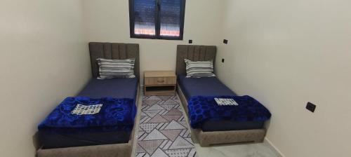 a room with two beds and a table at Tata hausse in Tatta