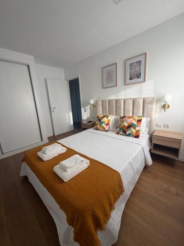 a bedroom with a large bed with two towels on it at Quinta do Passal - Country house in Parada de Ester