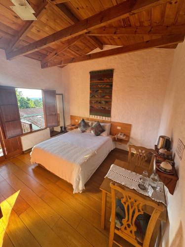 a bedroom with a large bed and a table at Terrazas de Salento in Salento