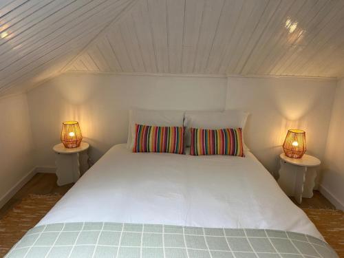 a bedroom with a white bed with two lamps at Vila Real Center Terrace in Vila Real