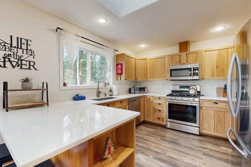 a kitchen with wooden cabinets and a white counter top at Riverfront retreat with panoramic river and forest views in Rhododendron
