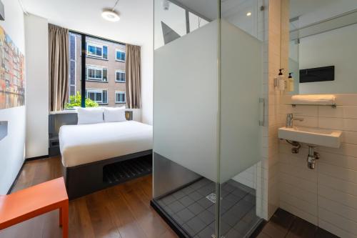 a bedroom with a bed and a sink in a room at easyHotel Amsterdam City Centre South in Amsterdam