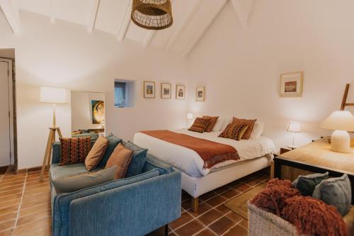a bedroom with a bed and two chairs and a couch at Azenha da Duquesa in Sintra