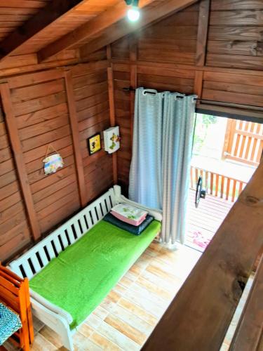 a small room with a bed and a window at Chalé piscina compartilhada com cozinha in Imbituba