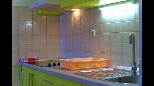 a kitchen sink with an orange container on the counter at Epicenter Apartments Split in Split