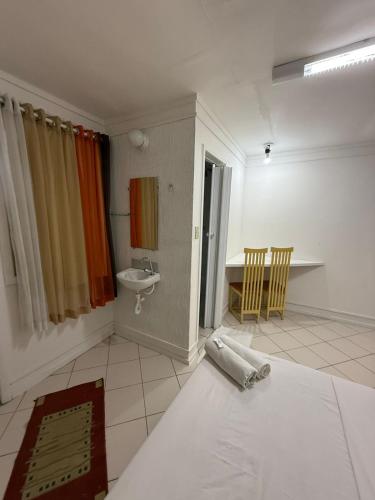 a bathroom with a bed and a sink in a room at Bahia Executivo Pousada in Zeca