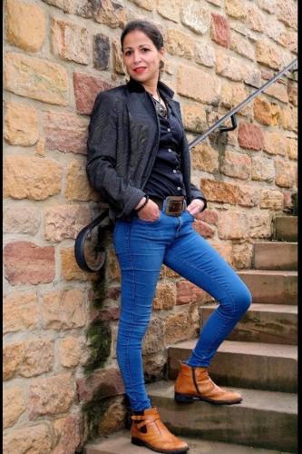 a woman standing on some stairs next to a brick wall at chambresdusoleil in Hoffen