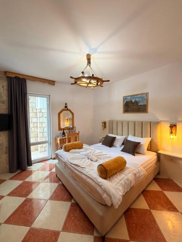a large bed in a bedroom with a checkered floor at Wiena Apartments in Ulcinj