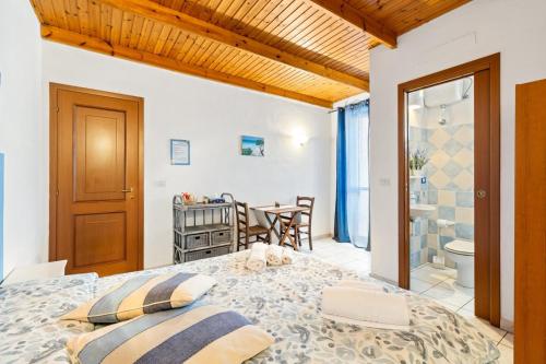 a bedroom with a large bed and a bathroom at Bed and Breakfast Cala Luna in Castelsardo