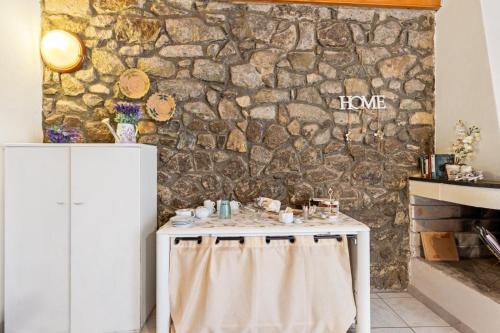 a table in a room with a stone wall at Bed and Breakfast Cala Luna in Castelsardo
