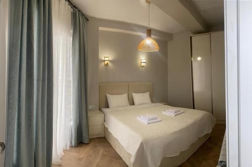 a bedroom with a bed and a large window at Home in Kutaisi