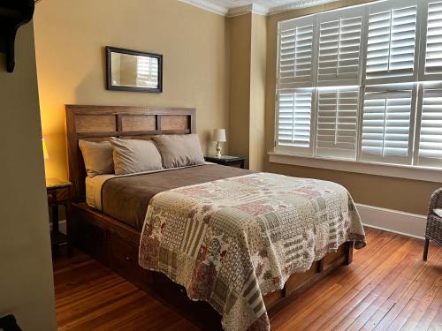 a bedroom with a bed and a window with shutters at Iron Horse Station in Hot Springs