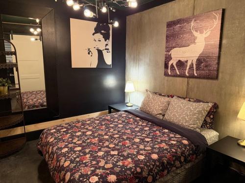 a bedroom with a bed and a painting on the wall at L'Industriel in Drummondville