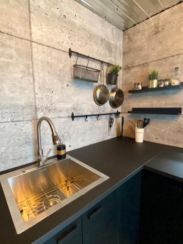 a kitchen with a sink and a counter with pots and pans at L'Industriel in Drummondville