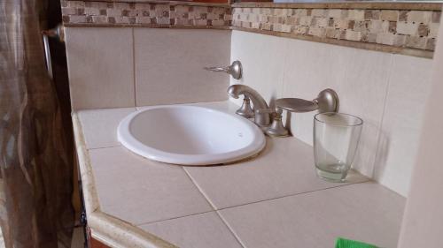 a white sink in a bathroom with a glass at Brisas Pura in Tandil