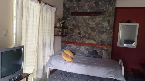 a room with a couch and a stone wall at Brisas Pura in Tandil
