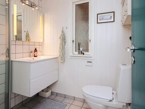 a white bathroom with a toilet and a sink at Idyllic Nature Retreat - By Traum Ferienwohnungen in Ulfborg