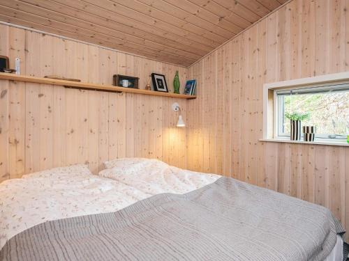 a bedroom with a bed in a wooden wall at Idyllic Nature Retreat - By Traum Ferienwohnungen in Ulfborg