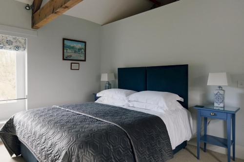 a bedroom with a large bed with a blue headboard at Edensor Cottage Bakewell Peak District in Bakewell