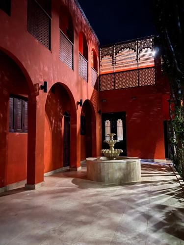 a courtyard with a fountain in the middle of a building at iBiZa Hostel in Beni Suef