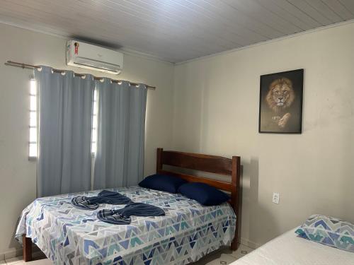 a bedroom with a bed with blue pillows on it at Suíte completa com cozinha no centro de Aquidauana in Aquidauana