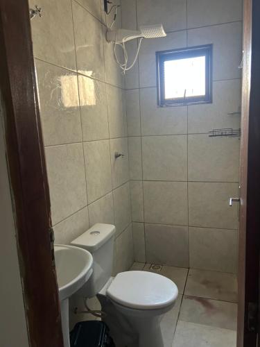a bathroom with a toilet and a sink at Suíte completa com cozinha no centro de Aquidauana in Aquidauana