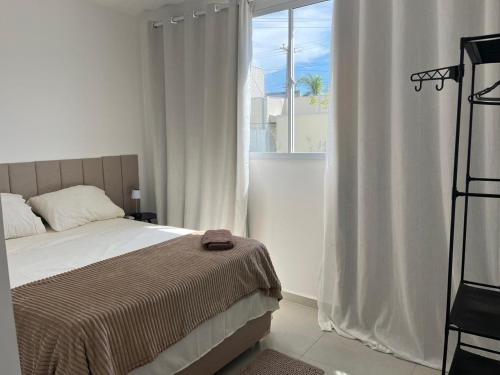 a bedroom with a bed and a large window at Vila dos Ventos in São Pedro da Aldeia