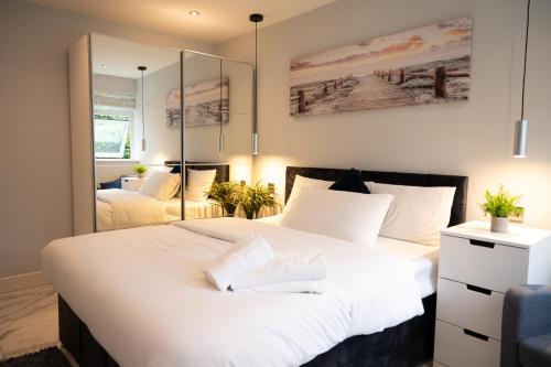 a bedroom with two beds and a mirror at Westfield luxurious Apartment in Birmingham