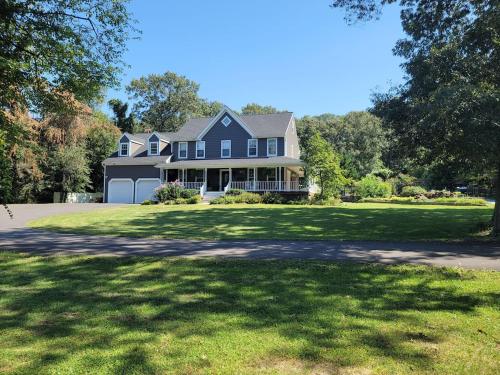 a large blue house with a large yard at Large Home with Private Pool, Gym, Sauna, 7 Bedrooms, Sleeps 21 in Severn