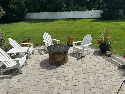 three white chairs and a fire pit in a yard at Large Home with Private Pool, Gym, Sauna, 7 Bedrooms, Sleeps 21 in Severn