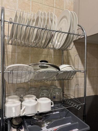 a shelf with plates and dishes on it in a kitchen at Luxury suite- 1bhk- Near Centaurus in Islamabad
