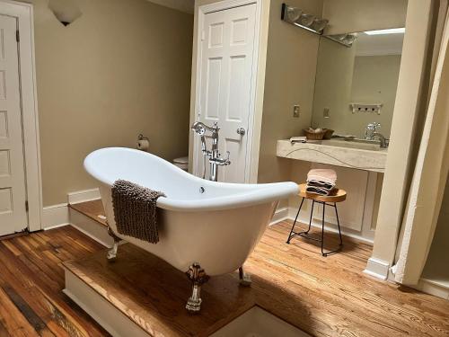 a bath tub in a bathroom with a sink and a mirror at Iron Horse Station in Hot Springs