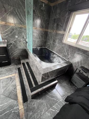 a bathroom with a bath tub with a window at Casa tequila club jacuzzi 4 in Arandas