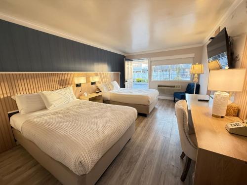 a hotel room with two beds and a desk at The Aventis Inn in Somers Point
