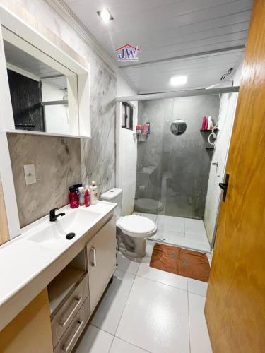 a bathroom with a shower and a sink and a toilet at Casa completa em Bagé ideal para familias ate 6 pessoas WiFi e excelente localização in Bagé