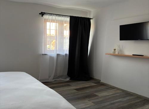 a bedroom with a bed and a window with a television at B&b la bessolina in Ivrea