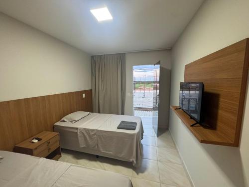 a hotel room with a bed and a television at Pousada Complexo Vibe in Baraúna