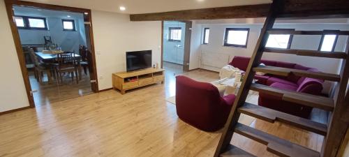 a living room with a couch and a tv at Woodlight Loft - Sauna & Nature Escape near Rothenburg ob der Tauber - Self Check-in in Diebach