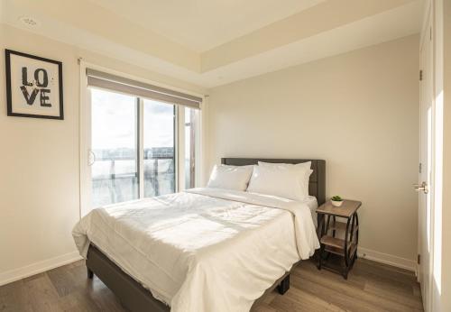 a white bedroom with a large bed and a window at Bisco Hill in Richmond Hill